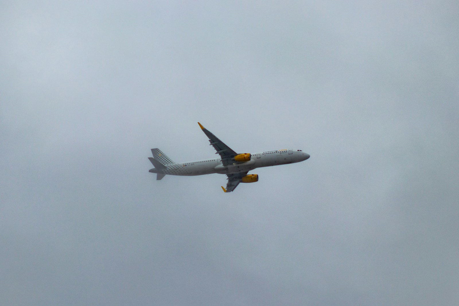 white and orange airliner flying on cloudy sky